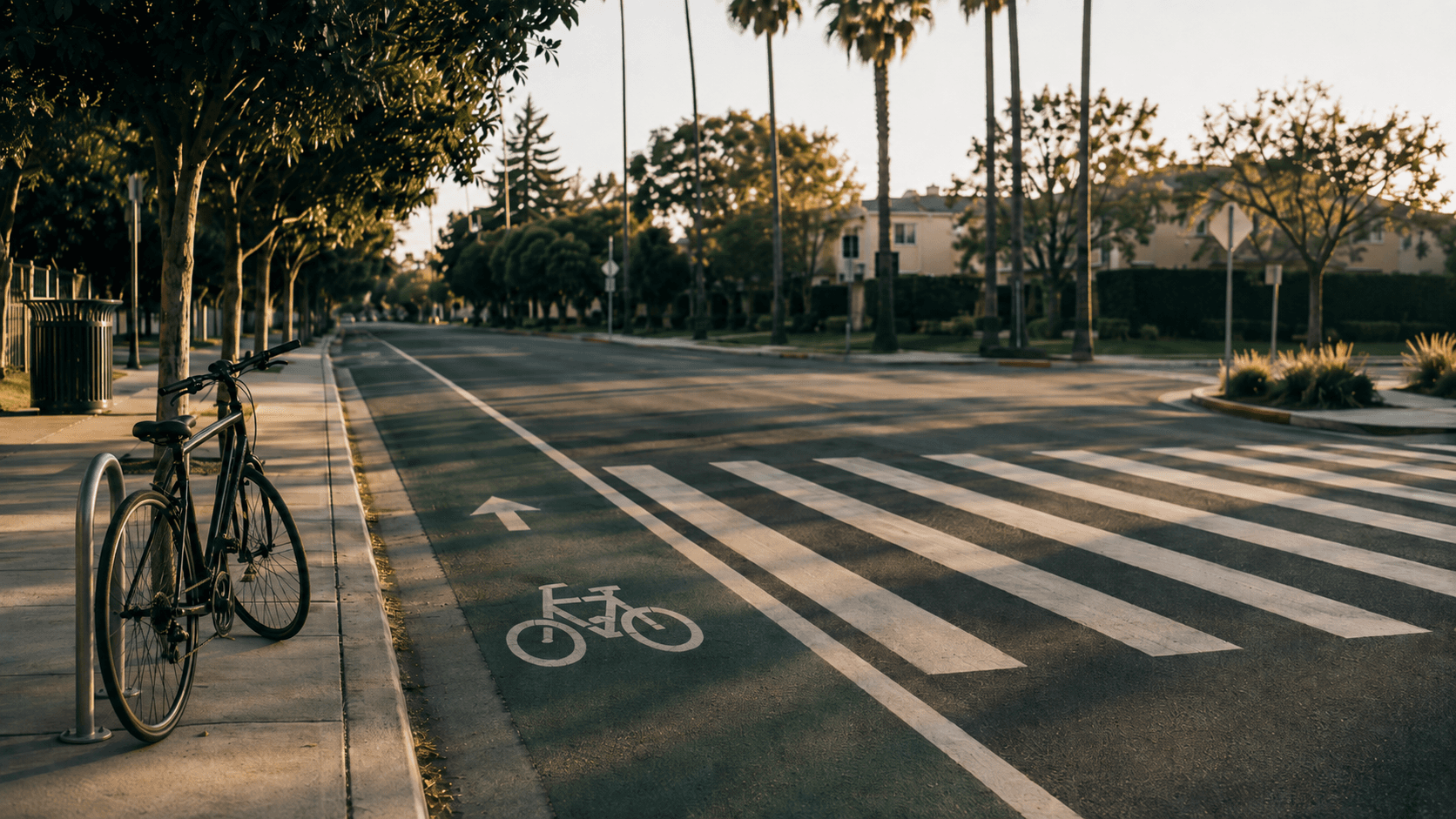A bicycle locked to a rack beside a green bike lane and a painted crosswalk
